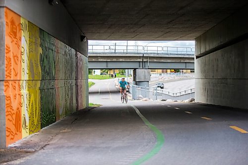 MIKAELA MACKENZIE / WINNIPEG FREE PRESS

David Pries cycles past a new mural by Natalie Baird at the Jubilee overpass bike route, which was painted as part of the Wheels of Courage volunteer program, in Winnipeg on Friday, June 11, 2021. Bike to Art day, where folks are encouraged to bike to public art displays as part of bike week, is on Saturday June 12. Standup.
Winnipeg Free Press 2021.