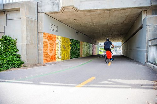 MIKAELA MACKENZIE / WINNIPEG FREE PRESS

Cyclists pass by a new mural by Natalie Baird at the Jubilee overpass bike route, which was painted as part of the Wheels of Courage volunteer program, in Winnipeg on Friday, June 11, 2021. Bike to Art day, where folks are encouraged to bike to public art displays as part of bike week, is on Saturday June 12. Standup.
Winnipeg Free Press 2021.