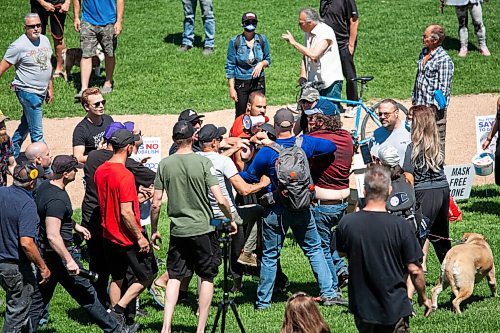 Daniel Crump / Winnipeg Free Press. A small altercation breaks out between anti restriction protestors and counter protestors. The counter protestors were asked to leave when they began making noise and throwing glitter and water at people. June 12, 2021.