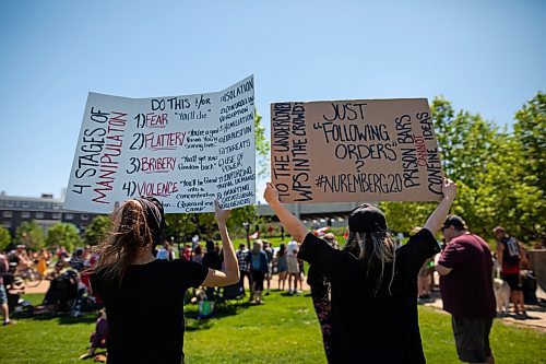 Daniel Crump / Winnipeg Free Press. Anti- restriction protestors hold up signs during a rally at the Forks on Saturday afternoon. June 12, 2021.
