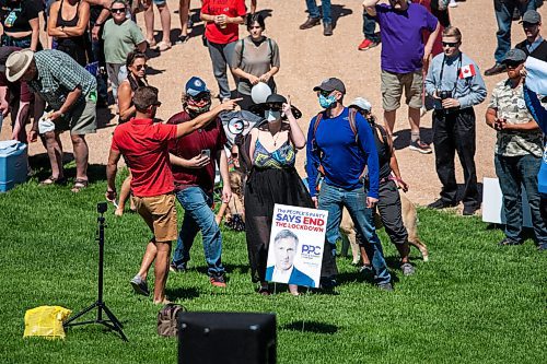 Daniel Crump / Winnipeg Free Press. Counter protestors are asked to leave by an organizer after the counter protestors start making noise and throwing glitter at people at an anti-restrictions rally at the Forks on Saturday afternoon. June 12, 2021.