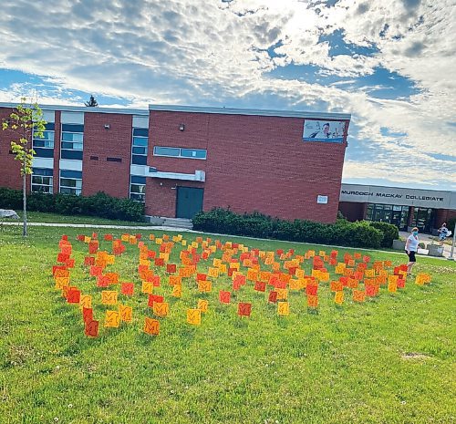 Canstar Community News Murdoch MacKay Collegiate students placed 215 stylized orange Ms on school grounds, one for each child whose remains have been discovered in Kamloops.