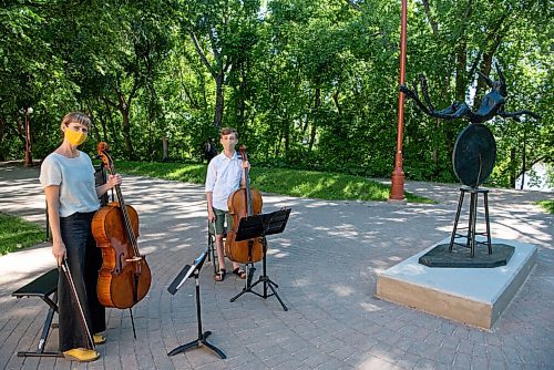 ALEX LUPUL / WINNIPEG FREE PRESS  

Cellists Leanne Zacharias and Jonah Hiebert perform next to Pirate Wheel, a 6.5-foot bronze sculpture by English artist Barry Flanagan, which stands behind the Manitoba Children's Museum in Winnipeg on Tuesday, June 15, 2021. The sculpture, which is on loan for the next year, is the newest piece of public art at The Forks.
