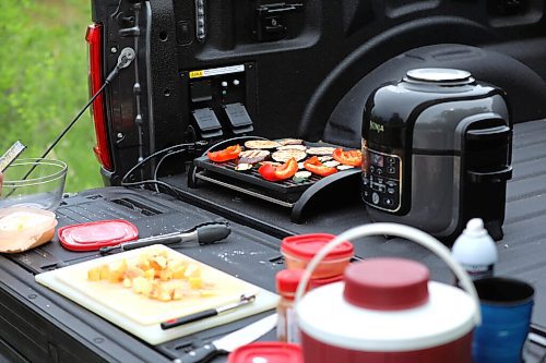RUTH BONNEVILLE / WINNIPEG FREE PRESS


ENT - cooking with Ford F-150

Subject: F-150 PowerBoost Hybrid and lunch

Landing the F-150 on the food page by using the electric outlets located on the plate bed of  the Electric truck to prepare lunch outside.   

Details: Will be cooking lunch using the hybrid truck's 7.6-kW on-board power. Air-fryer coconut shrimp with mango chutney, grilled summer vegetable salad, air-fryer apple fritter for dessert, virgin strawberry margarita. Come hungry.

Photos of kitchen set up in the bed, the truck in its 'wild' surroundings, candids of Kelly cooking, as well as prepared food photos.  
Grilled veggies and coconut shrimp.  

 
For the food page: Wed., June 23

June 16,, 2021

