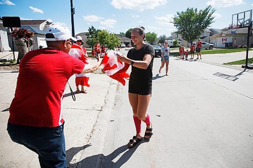 JOHN WOODS / WINNIPEG FREE PRESS
Winnipeg swimmer Kelsey Wog is handed a flag by her neighbour Gary Liu as she is greeted by her neighbours Thursday, June 17, 2021. Residents of Wogs street gathered at the end of their driveways to wish her well as she heads off to the national swimming trials. 

Reporter: Sawatzki