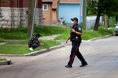 Daniel Crump / Winnipeg Free Press. A police officer crosses Burrows avenue near the spot where a 12-year-old boy was fatally stabbed Friday evening. June 19, 2021.