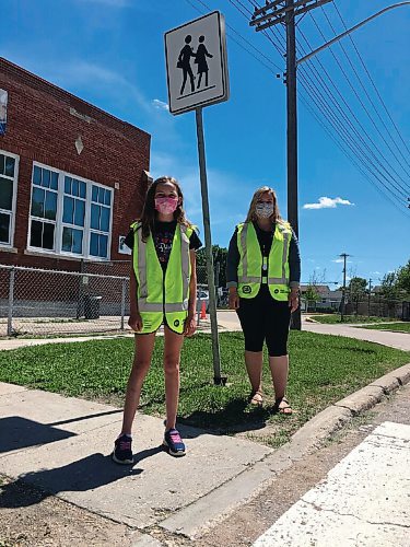 Canstar Community News One of two student patrol team captains, Sloane Borodenko, stands with patrol co-ordinator and teacher Delila Heinrichs at one of three intersections patrolled by Prince Edward School students in the patrol safety program.