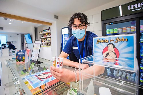 MIKAELA MACKENZIE / WINNIPEG FREE PRESS

Cannabis specialist Adam El-Gabalawy holds a few joints in front of the entry box for the new Joints for Jabs pro-vaccination program at the Osborne Delta 9 Cannabis Store in Winnipeg on Monday, June 21, 2021. For Temur story.
Winnipeg Free Press 2021.