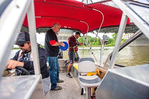 MIKAELA MACKENZIE / WINNIPEG FREE PRESS

Daniel Hidalgo (right) tows the line as Mitch Bourbonniere (centre) helps and Doug Park (left) drives the boat on the 2021 launch of Drag the Red, a search for missing and murdered, with a new boat (donated by Unifor) on the Red River near the Redwood Bridge in Winnipeg on Monday, June 21, 2021. Standup.
Winnipeg Free Press 2021.