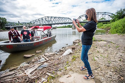 MIKAELA MACKENZIE / WINNIPEG FREE PRESS

Unifor Indigenous Liaison Gina Smoke takes a photo of the crew as Drag the Red launches their 2021 search for missing and murdered with a new boat (donated by Unifor) on the Red River near the Redwood Bridge in Winnipeg on Monday, June 21, 2021. Standup.
Winnipeg Free Press 2021.