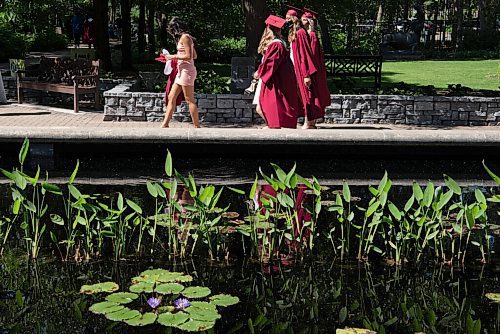 ALEX LUPUL / WINNIPEG FREE PRESS  

Westwood Collegiate graduates walk past a pond at the Leo Mol Sculpture Garden in Winnipeg on Wednesday, June 23, 2021.