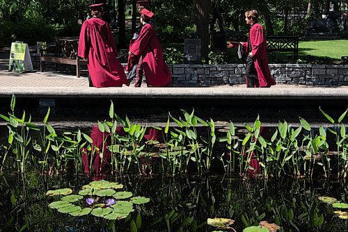 ALEX LUPUL / WINNIPEG FREE PRESS  

Westwood Collegiate graduates walk past a pond at the Leo Mol Sculpture Garden in Winnipeg on Wednesday, June 23, 2021.