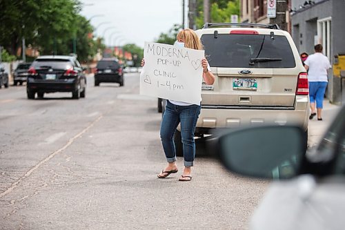 MIKAELA MACKENZIE / WINNIPEG FREE PRESS

Tracy Wark advertises a pop-up vaccine clinic to passers-by at the North End Women's Centre in Winnipeg on Wednesday, June 23, 2021. Standup.
Winnipeg Free Press 2021.