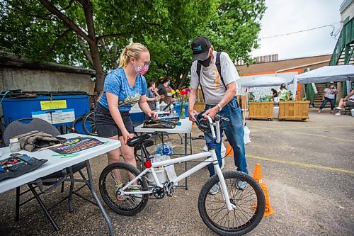 MIKAELA MACKENZIE / WINNIPEG FREE PRESS

Lasha Mackedenski (with The Wrench) hands Bruce Neil one of 30 free children's bikes while at a pop-up vaccine clinic at the North End Women's Centre in Winnipeg on Wednesday, June 23, 2021. Standup.
Winnipeg Free Press 2021.