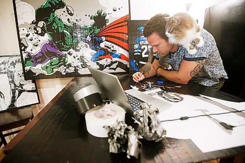 JOHN WOODS / WINNIPEG FREE PRESS
Levi Sobering, duct tape artist and founder of Duct Tape Dynasty, a home-based biz that produces duct tape art, works on a new piece as his cat Mylo sits on his shoulders in his home in Winnipeg Wednesday, June 23, 2021.

Reporter: Sanderson