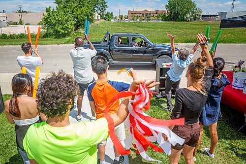 MIKE DEAL / WINNIPEG FREE PRESS
Grade 12 grad Keona Anoling waves as she drives up to receive her diploma and take photos while being cheered on by teachers and staff outside École Secondaire Sisler High School (1360 Redwood Ave) Thursday afternoon.
210624 - Thursday, June 24, 2021.