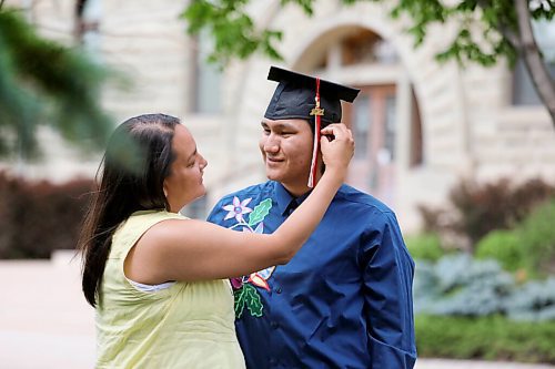 RUTH BONNEVILLE / WINNIPEG FREE PRESS

49.8 VIRUS THREE FAMILIES: following three families in 3 different types of schooling. 

Photo of Josiah Parenteau's mom, Anna Parenteau, fixing Josiah's grad tassel outside his high school,  U of W Collegiate, while dressed in his graduation cap and traditional embellished dress shirt, Thursday.  His mom drove him to pick up his graduation cap and gown for an upcoming grad celebration.  

Story: following three families  a homeschooling family, remote learning family and in-class instruction family  to document their learning curves during the pandemic. The last (fourth) edition will run July 3.

June 24,, 2021

