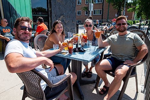 Daniel Crump / Winnipeg Free Press. Friends (L to R) Brad Erratt, Silvia Savo, Morgan Jackson, and Nick Luhowy meet for drinks on the patio of Bar Italia on Corydon. Along with businesses such as gyms and hair salons, patios can once again reopen as eased pandemic restrictions take effect on Saturday. June 26, 2021.