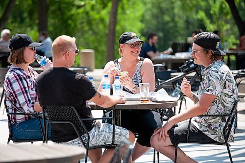 Daniel Crump / Winnipeg Free Press. (L to R) Kira Nederlof, Rob Nederlof, Marina Nederlof, and Travis Houtstra meet at the patio under the canopy at the Forks. Along with businesses such as gyms and hair salons, patios can once again reopen as eased pandemic restrictions take effect on Saturday. June 26, 2021.