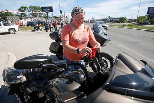 JOHN WOODS / WINNIPEG FREE PRESS
Tina Inkster, ties an orange ribbon to her bike, as about 60-70 motorcycle riders get ready to hit the road to the residential school in Brandon from a business on Pembina Highway in Winnipeg Sunday, June 27, 2021. The group said the ride is a memorial for the children found in unmarked graves at  residential schools and to stand in solidarity with the Indigenous community.

Reporter: Standup