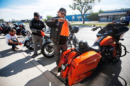 JOHN WOODS / WINNIPEG FREE PRESS
From left, John Wiebe with Joseph Hernandez and his dad Jose, tie an orange ribbon to their bikes, as about 60-70 motorcycle riders get ready to hit the road to the residential school in Brandon from a business on Pembina Highway in Winnipeg Sunday, June 27, 2021. The group said the ride is a memorial for the children found in unmarked graves at  residential schools and to stand in solidarity with the Indigenous community.

Reporter: Standup