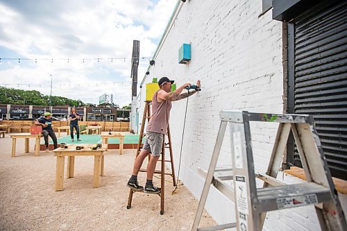 MIKAELA MACKENZIE / WINNIPEG FREE PRESS

FOR BEN SIGURDSON STORY --- Darren Lannoo puts up planter boxes at The Garden at 955 Portage Avenue in Winnipeg on Wednesday, June 30, 2021. The former parking lot, now converted to a new outdoor beer garden, is opening tomorrow (July 1st). 
Winnipeg Free Press 2021.