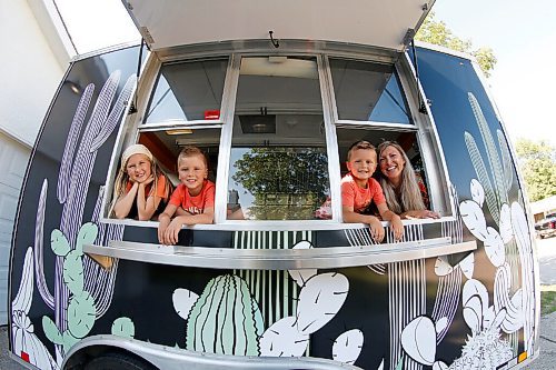 JOHN WOODS / WINNIPEG FREE PRESS
Erin Popoff, a former WestJet pilot laid off because of the pandemic, is photographed with her children Kodiak, 5, Makeiff, 7, and Olive, 9, and her new food truck trailer, Poacht, outside her home in Winnipeg Wednesday, June 30, 2021. Popoff launched the pandemic pivot small business to make up for being let go by WestJet.

Reporter: Durrani