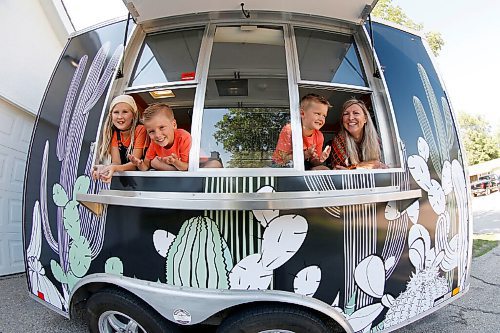 JOHN WOODS / WINNIPEG FREE PRESS
Erin Popoff, a former WestJet pilot laid off because of the pandemic, is photographed with her children Kodiak, 5, Makeiff, 7, and Olive, 9, and her new food truck trailer, Poacht, outside her home in Winnipeg Wednesday, June 30, 2021. Popoff launched the pandemic pivot small business to make up for being let go by WestJet.

Reporter: Durrani