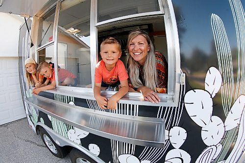 JOHN WOODS / WINNIPEG FREE PRESS
Erin Popoff, a former WestJet pilot laid off because of the pandemic, is photographed with her children Kodiak, 5, Makeiff, 7, and Olive, 9, and her new food truck trailer, Poacht, outside her home in Winnipeg Wednesday, June 30, 2021. Popoff launched the pandemic pivot small business to make up for being let go by WestJet.

Reporter: Durrani