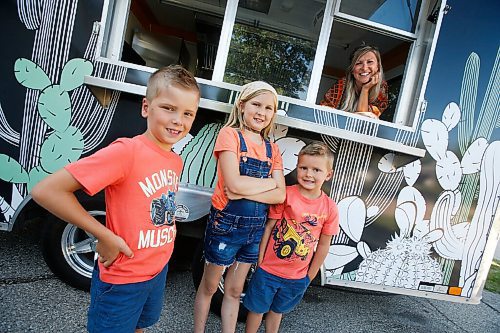 JOHN WOODS / WINNIPEG FREE PRESS
Erin Popoff, a former WestJet pilot laid off because of the pandemic, is photographed with her children Kodiak, 5, Makeiff, 7, and Olive, 9, and her new food truck trailer, Poacht, outside her home in Winnipeg Wednesday, June 30, 2021. Popoff launched the pandemic pivot small business to make up for being let go by WestJet.

Reporter: Durrani