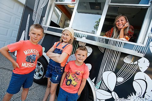 JOHN WOODS / WINNIPEG FREE PRESS
Erin Popoff, a former WestJet pilot laid off because of the pandemic, is photographed with her children Kodiak, 5, Makeiff, 7, and Olive, 9, and her new food truck trailer, Poacht, outside her home in Winnipeg Wednesday, June 30, 2021. Popoff launched the pandemic pivot small business to make up for being let go by WestJet.

Reporter: Durrani