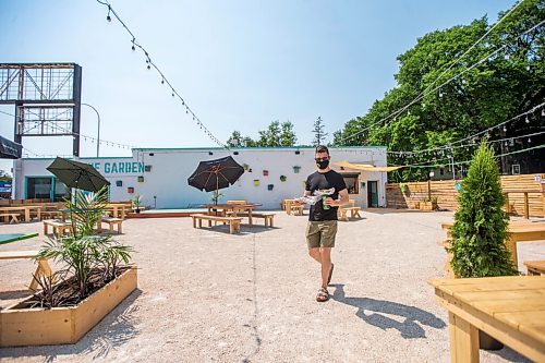 MIKAELA MACKENZIE / WINNIPEG FREE PRESS

Scott Angus walks drinks and food back to his table at Garden 955, a new beer garden at 955 Portage Avenue, in Winnipeg on Friday, July 2, 2021. For Ben Sigurdson story.
Winnipeg Free Press 2021.