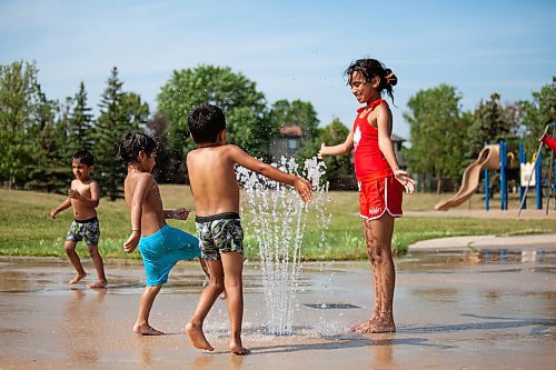 Daniel Crump / Winnipeg Free Press. Prisha Choubhari (right), Adbul Rafay (middle), and Adhiraj Choubhari (right) play at a spray pad in Lindenwoods on Saturday afternoon. Temperatures reached 36 degrees celsius in Winnipeg as heat warnings covered large parts of the province. July 3, 2021.