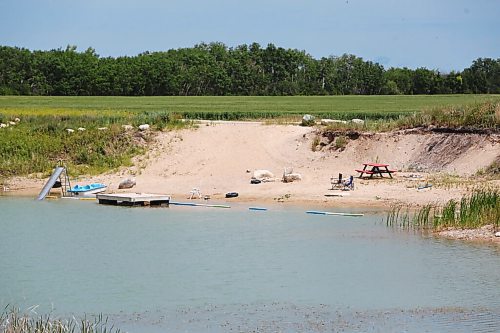 MIKE DEAL / WINNIPEG FREE PRESS
A water filled rock quarry with a slide and floating dock just off the Taylor Road north of Petersfield, MB, where a four-year-old boy drowned on Sunday according to the Selkirk RCMP. 
210705 - Monday, July 5, 2021