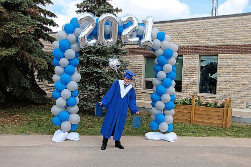 Canstar Community News Adam Cox holds his graduation gifts as he prepares to take pictures at Sanford Collegiate's makeshift photo spot. Cox graduated in the high school's parking lot on June 24. (GABRIELLE PICHÉ/CANSTAR COMMUNITY NEWS/HEADLINER)
