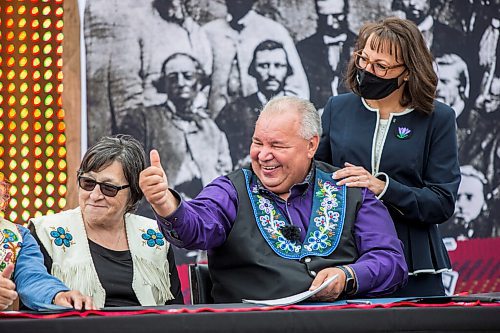 MIKAELA MACKENZIE / WINNIPEG FREE PRESS

Manitoba Metis Federation (MMF) president David Chartrand gives a thumbs-up after signing the agreement, which gives the MMF formal recognition to lead the Manitoba Metis and represent them, as MMF vice president Leah LaPlante (left) and Chartrand's wife, Glorian Chartrand, watch at a signing ceremony at Upper Fort Garry Heritage Provincial Park in Winnipeg on Tuesday, July 6, 2021. For Carol Sanders story.
Winnipeg Free Press 2021.