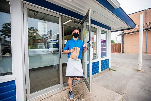 MIKAELA MACKENZIE / WINNIPEG FREE PRESS

Brendan Ellis brings orders out to folks waiting in their cars at the Dairi-Wip Drive In, one of the more iconic burger joints in town, in Winnipeg on Tuesday, July 6, 2021. For Dave Sanderson story.
Winnipeg Free Press 2021.