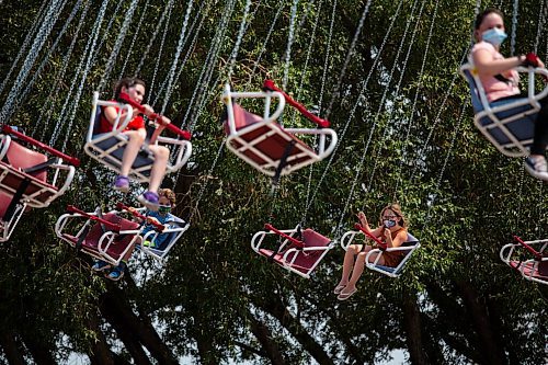 Daniel Crump / Winnipeg Free Press. Kids ride the swing carousel at Tinkertown on Saturday afternoon. The amusement park has been seeing good attendance since reopening after the most recent round or pandemic restrictions were eased. July 10, 2021.