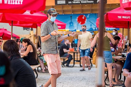 MIKAELA MACKENZIE / WINNIPEG FREE PRESS

David Safruk carries flights of beer back to his table before Bullrider plays at Blue Note Park in Winnipeg on Friday, July 9, 2021. For Melissa Martin story.
Winnipeg Free Press 2021.