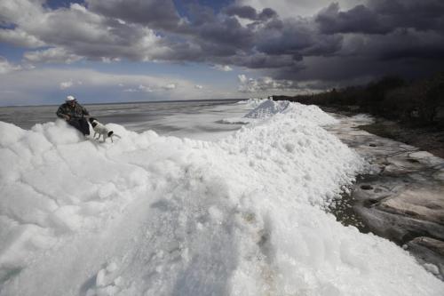 BORIS.MINKEVICH@FREEPRESS.MB.CA  100404 BORIS MINKEVICH / WINNIPEG FREE PRESS A man and his dog explore on top of a massive pile of lake ice at Stephenson Point near Winnipeg Beach. **the guy's name was Gary but said didn't want his name used. He lives in the area.**