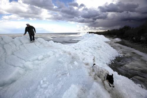 BORIS.MINKEVICH@FREEPRESS.MB.CA  100404 BORIS MINKEVICH / WINNIPEG FREE PRESS A man and his dog explore on top of a massive pile of lake ice at Stephenson Point near Winnipeg Beach. **the guy's name was Gary but said didn't want his name used. He lives in the area.**