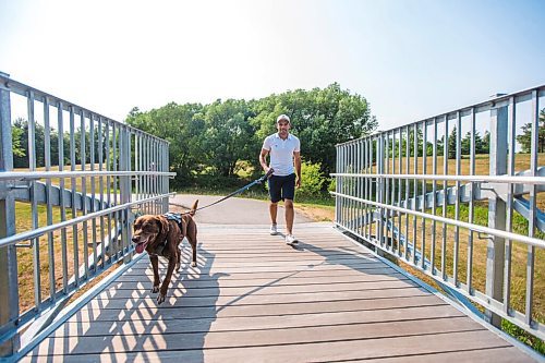 MIKAELA MACKENZIE / WINNIPEG FREE PRESS

Gordon Templeton and his dog, Nala, demonstrate the dog restraint and leash system that Templeton created at King's Park in Winnipeg on Friday, July 16, 2021. For Dave Sanderson story.
Winnipeg Free Press 2021.