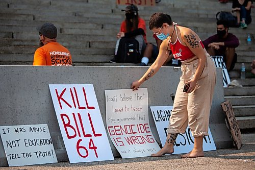 Daniel Crump / Winnipeg Free Press. A protestor puts up at sign at the ProtectEdMB rally at the Manitoba legislature, Saturday morning. The rally was organized as a response to comments made by premier Brian Pallister and Indigenous relations minister, Alan Lagimodiere. July 17, 2021.