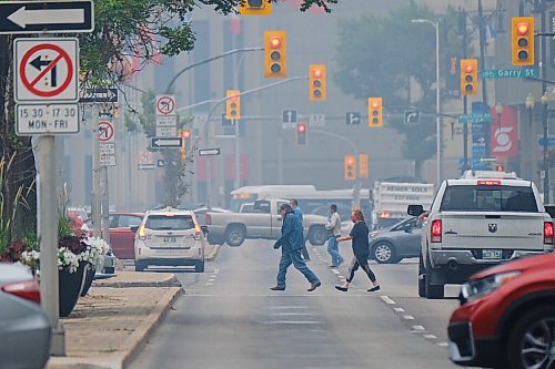 MIKE DEAL / WINNIPEG FREE PRESS
A smokey haze fills the air from forest fires as pedestrians cross Portage Avenue in Winnipegs Downtown Monday afternoon. 
210719 - Monday, July 19, 2021