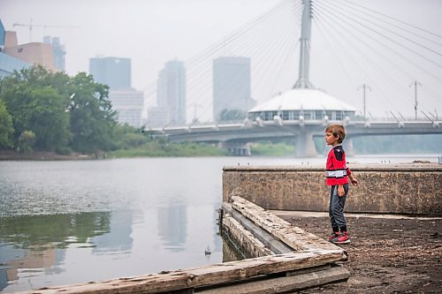 MIKAELA MACKENZIE / WINNIPEG FREE PRESS

Matteo Hebert (eight) throws sticks and mud into the river on the Tache Promenade on a smoky day in Winnipeg on Tuesday, July 20, 2021. Standup.
Winnipeg Free Press 2021.