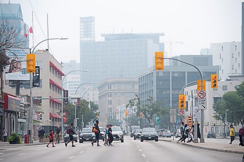 MIKE SUDOMA / Winnipeg Free Press
Pedestrians walk across Portage Ave as smoke from surrounding forest fires fill the air Wednesday afternoon
July 21, 2021