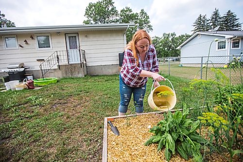 MIKAELA MACKENZIE / WINNIPEG FREE PRESS

Morden resident Theresa Dueck uses buckets to water garden boxes in her yard on Thursday, July 22, 2021. She has been collecting rain water and the water usually wasted before shower/bath water gets warm to water her vegetable garden. For Kevin Rollason story.
Winnipeg Free Press 2021.
