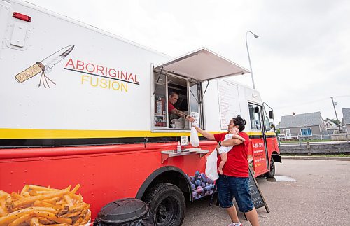 MIKE SUDOMA / Winnipeg Free Press
Tara Hall, owner of Aboriginal Fusion, hands Noreen Spence and her baby Jordan their order during a busy Thursday afternoon
July 22, 2021