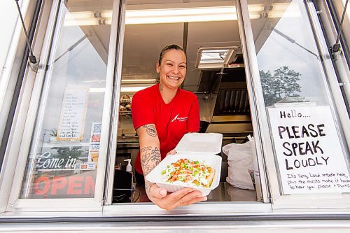 MIKE SUDOMA / Winnipeg Free Press
Tara Hall, owner and chef of Aboriginal Fusion, shows off an order of Bannock Tacos though the delivery window of her food truck Thursday afternoon
July 22, 2021