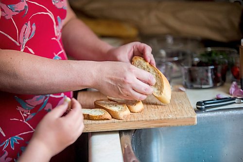 MIKAELA MACKENZIE / WINNIPEG FREE PRESS

Céline Land and her son, Félix (nine), rub garlic cloves onto toasted baguette while making summer bruschetta with Vegan Fromagerie feta at home in Winnipeg on Friday, July 23, 2021. For Eva Wasney story.
Winnipeg Free Press 2021.